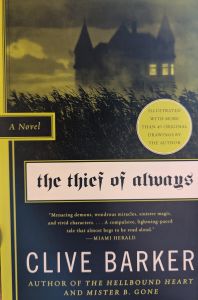 A slightly crooked photo of the book cover for The Thief of Always by Clive Barker. The background shows the black silhouette of grass, behind which stands a large house in front of a cloudy sky. The image is rendered in black, grey, and yellow. A vertical bar of yellow sets off the left side of the cover. A yellow circle in the middle right of the cover reads, "ILLUSTRATED WITH MORE THAN 40 ORIGINAL DRAWINGS BY THE AUTHOR". A pale beige band below this is the background for the title of the book. The other text, from top to bottom, reads, "A Novel / the thief of always / 'Menacing demons, wondrous miracles, sinister magic, and vivid characters... A compulsive, lightning-paced tale that almost begs to be read aloud.' - MIAMI HERALD / CLIVE BARKER / AUTHOR OF THE HELLBOUND HEART AND MISTER B. GONE".
